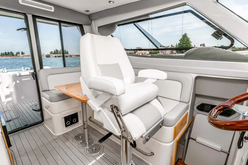 Slide: The Image of Interior of 2021 ArrowCat 320 boat with white seating and wooden accents. - 23