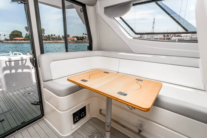 Slide: The Image of Interior of 2021 ArrowCat 320 boat with seating and foldable table by large windows. - 20