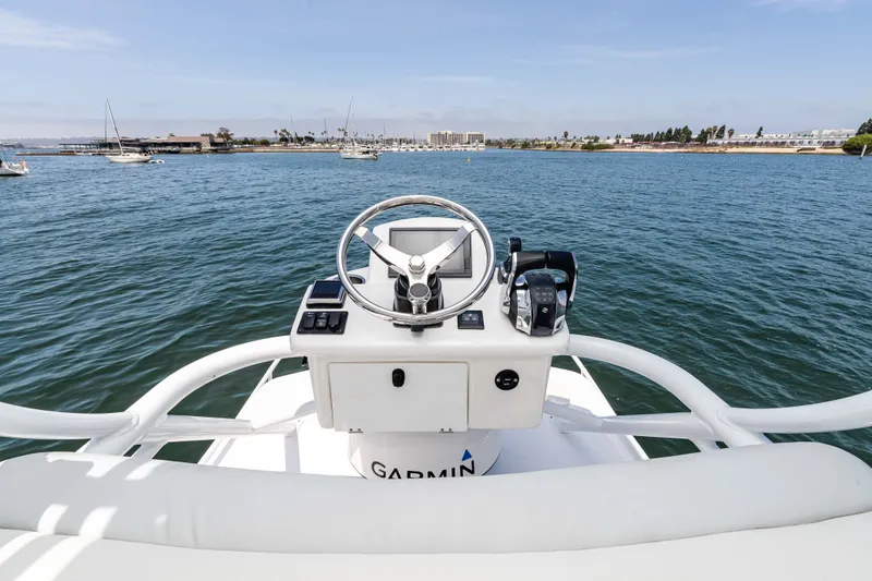 Slide: The Image of Helm of 2021 ArrowCat 320 boat with scenic waterfront view. - 16