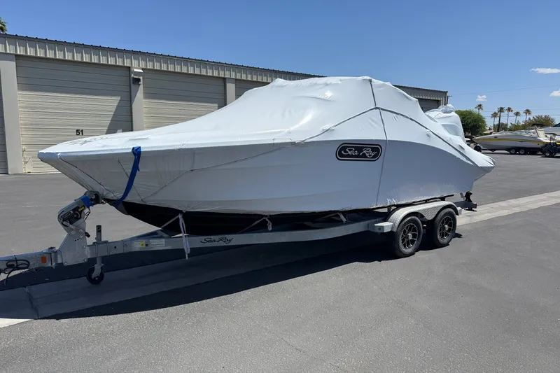 Slide: The Image of 2026 Sea Ray SPX 210 Outboard boat covered on a trailer in a parking lot. - 3
