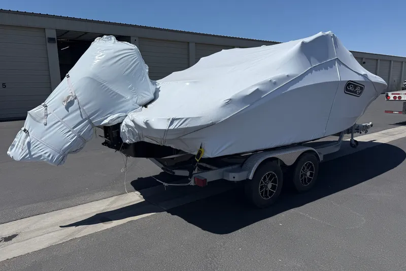 Slide: The Image of 2026 Sea Ray SPX 210 Outboard boat covered on a trailer in a parking lot. - 4