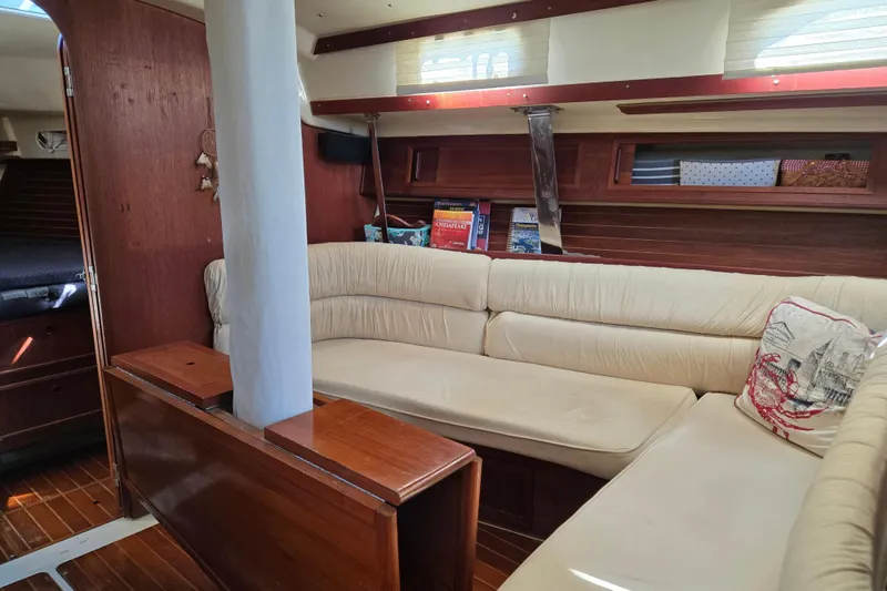 Slide: The Image of Interior of a 1990 Pearson 385 sailboat with cozy seating and wooden accents. - 8