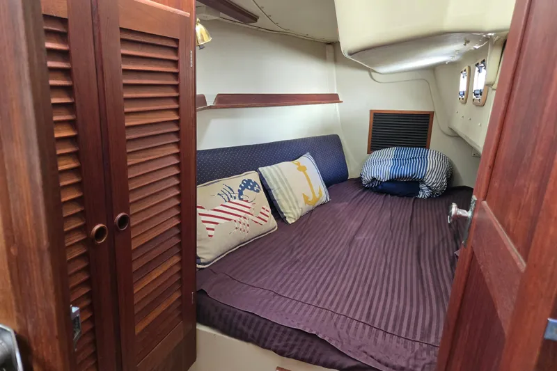 Slide: The Image of Cozy cabin interior of 1990 Pearson 385 sailboat with nautical-themed pillows. - 22