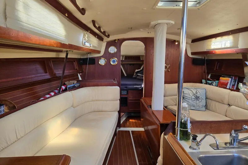 Slide: The Image of Interior of a 1990 Pearson 385 sailboat with cozy seating and wooden accents. - 7