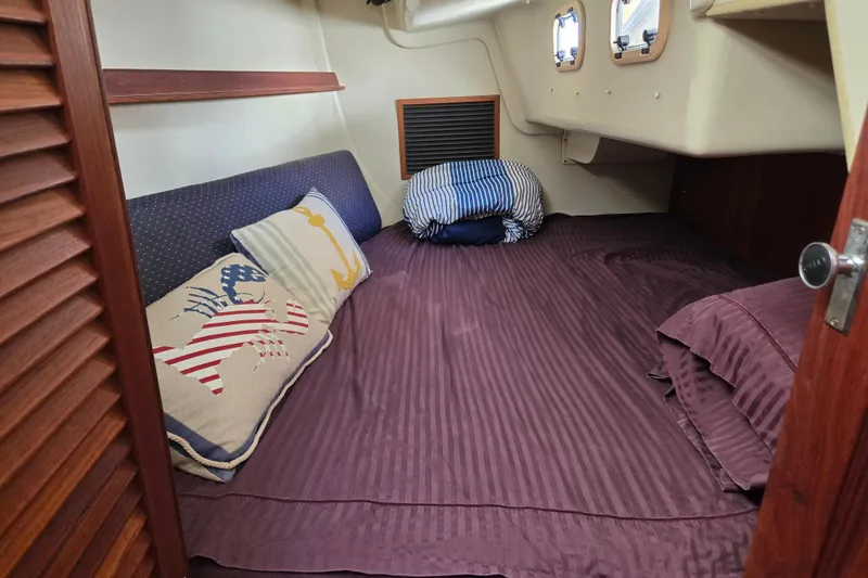 Slide: The Image of Cozy cabin interior of a 1990 Pearson 385 sailboat with nautical-themed pillows. - 21