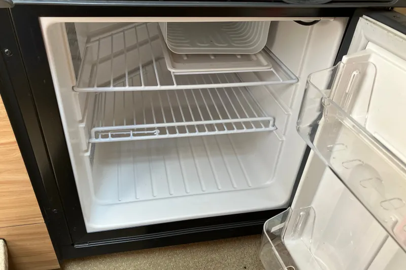 Slide: The Image of Empty refrigerator inside a 2006 Sea Ray 290 Sun Sport boat. - 23