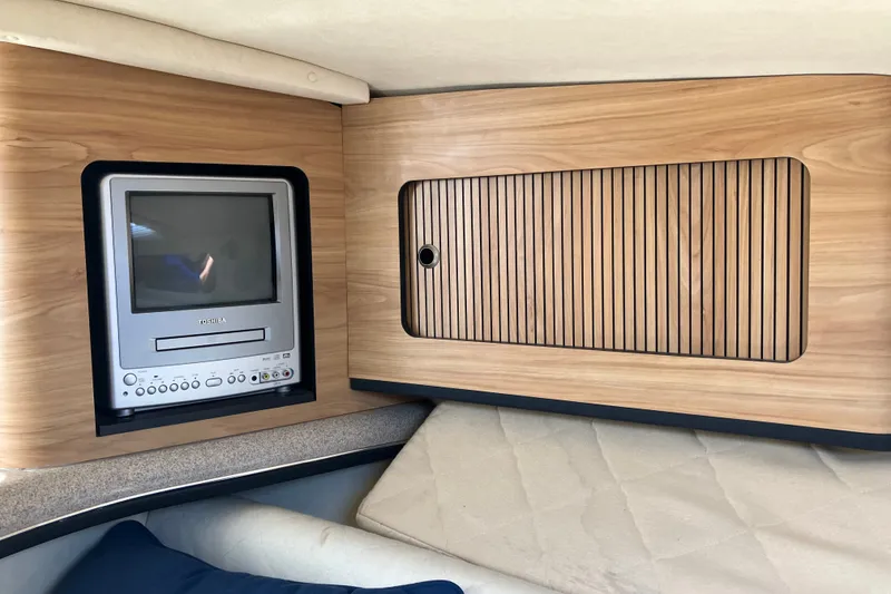 Slide: The Image of 2006 Sea Ray 290 Sun Sport cabin interior with TV and wooden paneling. - 24