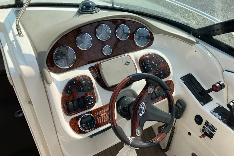 Slide: The Image of 2006 Sea Ray 290 Sun Sport dashboard with wood accents and steering wheel. - 7