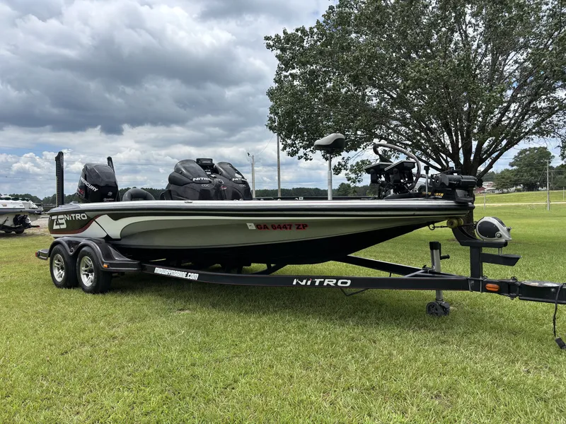 Slide: The Image of A 2011 Nitro Z9 CDC boat on a trailer sits on a grassy field under a cloudy sky. - 4
