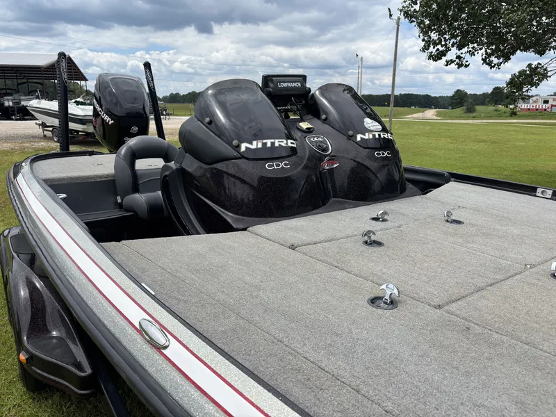Slide: The Image of A 2011 Nitro Z9 CDC boat with dual outboard motors, parked on a trailer on grass. - 10