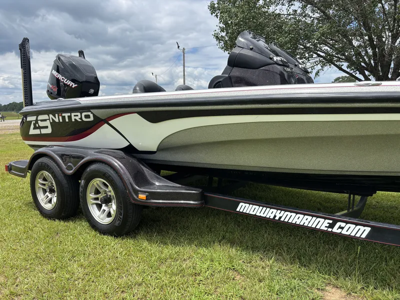 Slide: The Image of A 2011 Nitro Z9 CDC boat on a trailer, featuring a Mercury engine, sits on grass. - 7