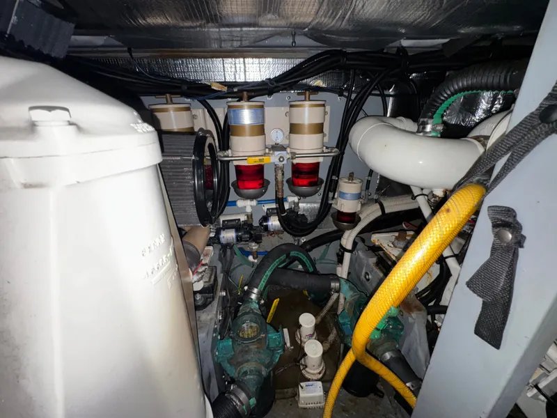Slide: The Image of The engine room of a 2000 Sea Ray 420 Aft Cabin showing engines and hoses. - 24