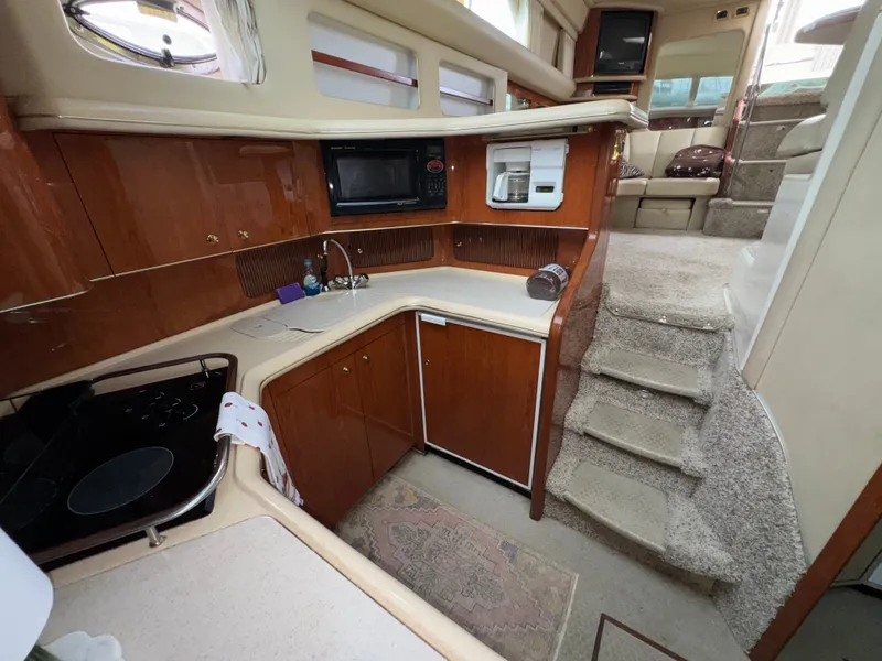 Slide: The Image of The galley of a 2000 Sea Ray 420 Aft Cabin with wood cabinets and carpeted flooring. - 21