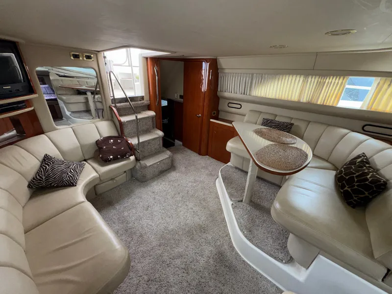Slide: The Image of Interior of the 2000 Sea Ray 420 Aft Cabin with beige sofa and dining table. - 9