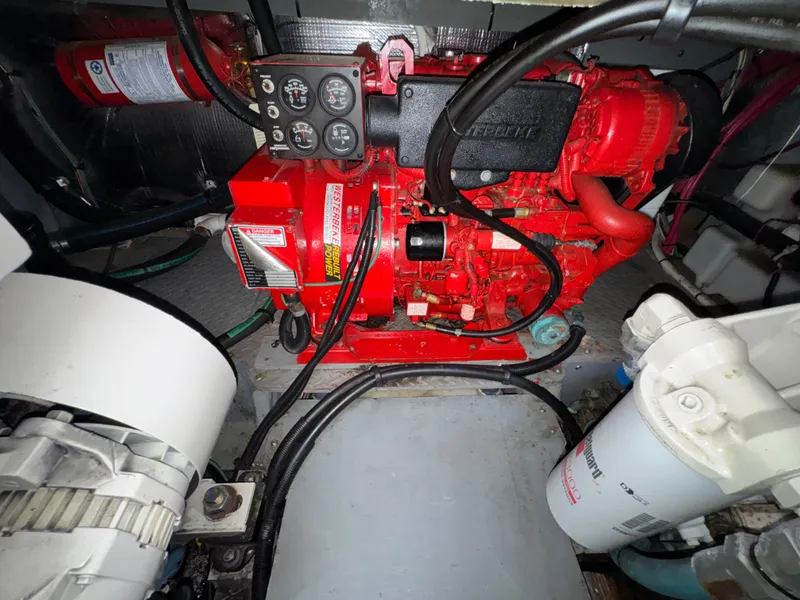 Slide: The Image of A red engine in an engine room with various hoses and filters. - 22
