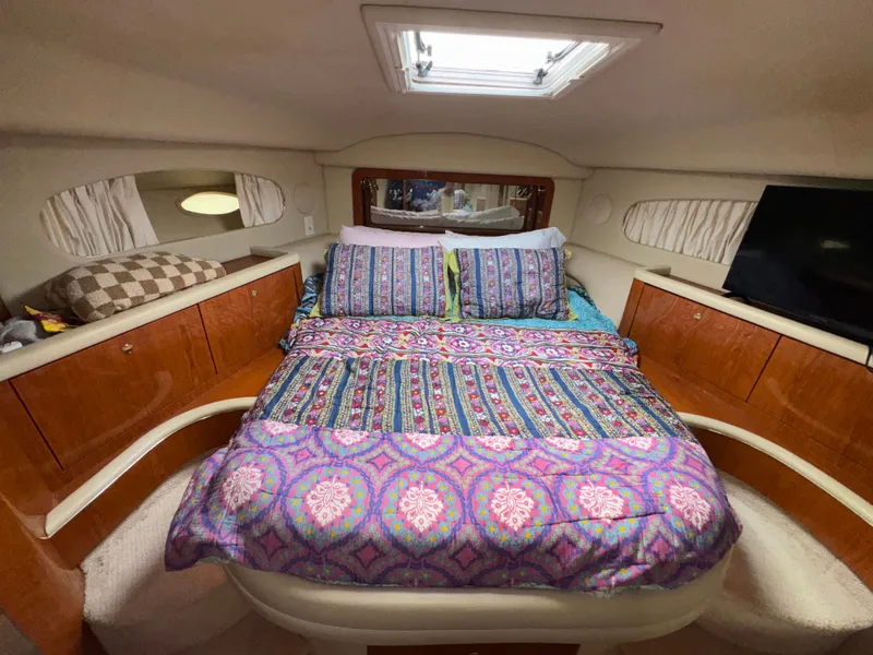 Slide: The Image of The 2000 Sea Ray 420 Aft Cabin features a cozy bed with colorful bedding in a well-lit cabin. - 17