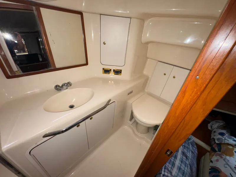 Slide: The Image of The image shows a bathroom in a 2000 Sea Ray 420 Aft Cabin with a sink and toilet. - 12