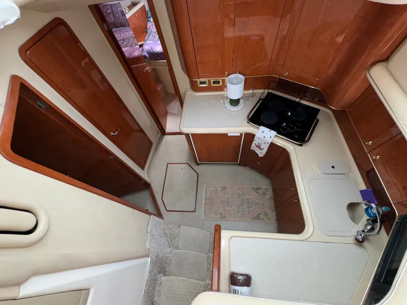 Slide: The Image of Interior of the 2000 Sea Ray 420 Aft Cabin featuring a kitchen and wooden cabinetry. - 15