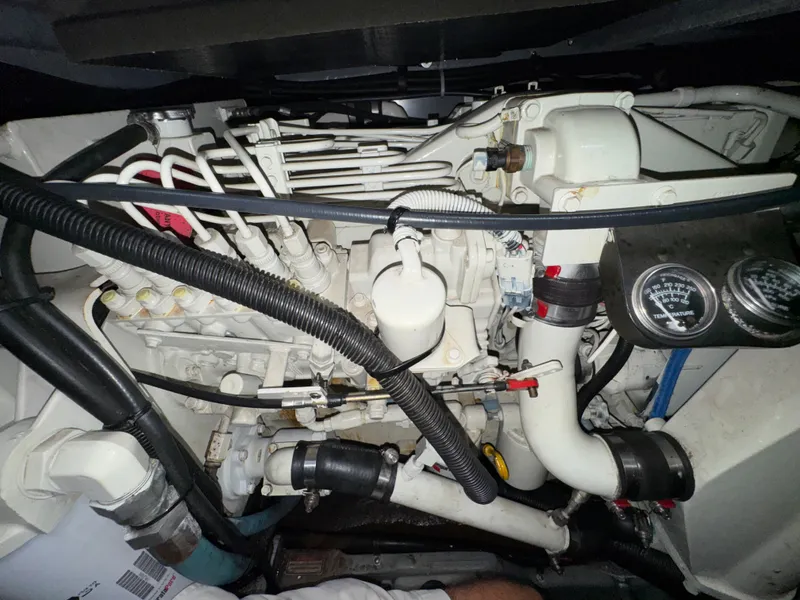 Slide: The Image of The engine room of a 2000 Sea Ray 420 Aft Cabin features complex piping and gauges. - 25