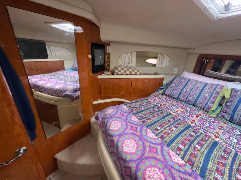 Slide: The Image of The 2000 Sea Ray 420 Aft Cabin features a cozy bed with colorful bedding in a warm cabin. - 18