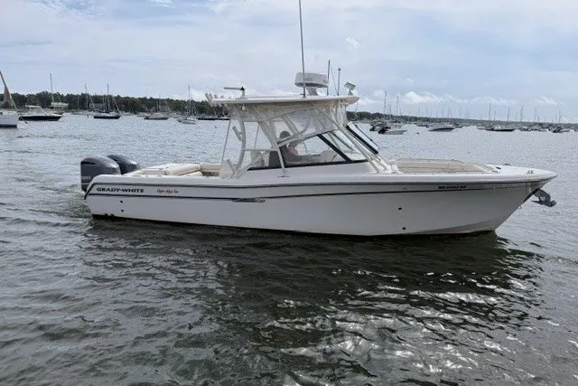 Slide: The Image of 2015 Grady-White Freedom 285 boat on calm water, surrounded by other vessels. - 1