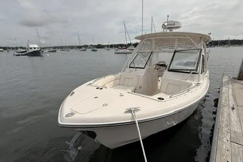 Slide: The Image of 2015 Grady-White Freedom 285 boat docked in a marina with overcast skies. - 2