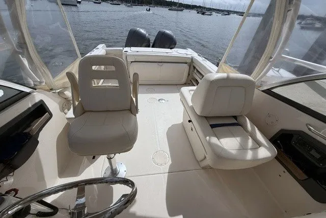 Slide: The Image of 2015 Grady-White Freedom 285 boat interior with seating, overlooking a serene water view. - 10