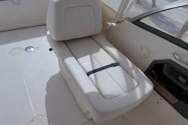 Slide: The Image of 2015 Grady-White Freedom 285 boat interior with white seating and control panel. - 11