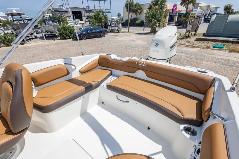 Slide: The Image of 2021 Stingray 182 SC boat interior with tan seating and Suzuki outboard motor. - 33