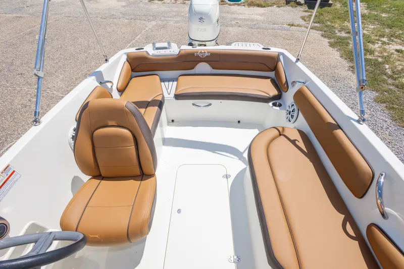 Slide: The Image of 2021 Stingray 182 SC boat interior with tan seating and steering wheel. - 32