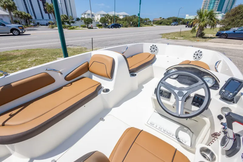 Slide: The Image of 2021 Stingray 182 SC boat interior with tan seating and modern dashboard controls. - 25