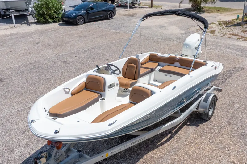 Slide: The Image of 2021 Stingray 182 SC boat on trailer, featuring sleek design and tan seating. - 4