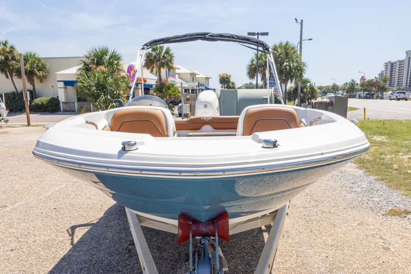 Slide: The Image of 2021 Stingray 182 SC boat on trailer, parked outdoors near palm trees. - 17