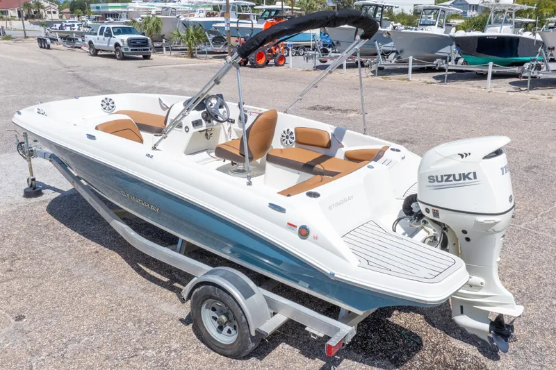 Slide: The Image of 2021 Stingray 182 SC boat with Suzuki outboard motor on a trailer in a marina. - 40