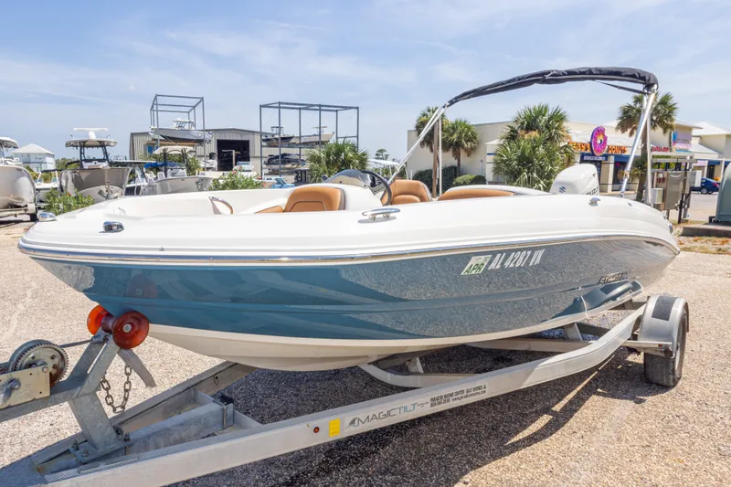 Slide: The Image of 2021 Stingray 182 SC boat on trailer, parked outdoors under clear sky. - 16