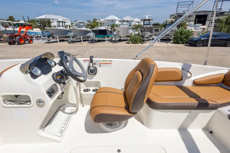 Slide: The Image of 2021 Stingray 182 SC boat interior with tan seating and steering console. - 36