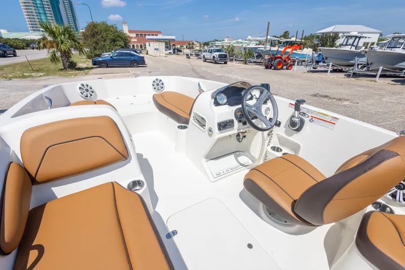 Slide: The Image of 2021 Stingray 182 SC boat interior with tan seating and modern dashboard. - 24