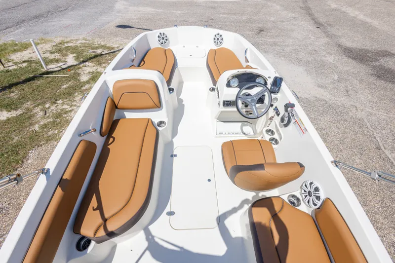 Slide: The Image of 2021 Stingray 182 SC boat interior with tan seating and modern dashboard. - 23