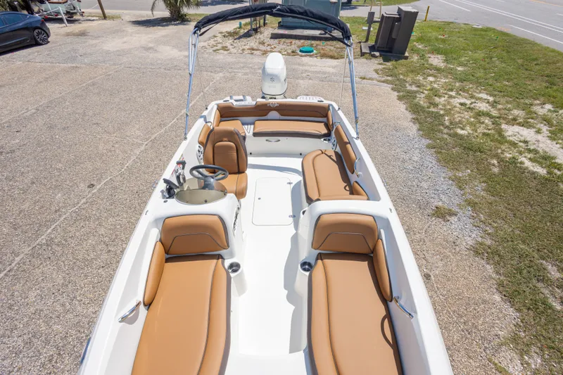Slide: The Image of 2021 Stingray 182 SC boat with tan seating, parked on a gravel lot. - 28
