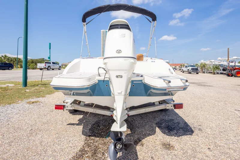 Slide: The Image of 2021 Stingray 182 SC boat on trailer, rear view, sunny day, parking lot setting. - 12