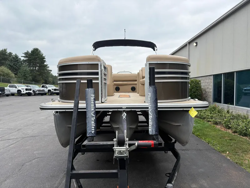 Slide: The Image of A 2019 Harris Sunliner 230 pontoon boat on a trailer in front of a building. - 3