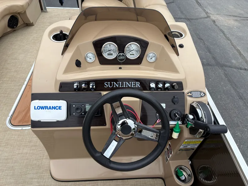 Slide: The Image of The image shows the helm of a 2019 Harris Sunliner 230 with a steering wheel and gauges. - 13
