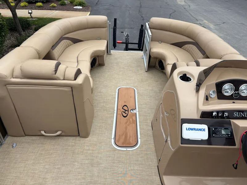 Slide: The Image of The image shows the interior of a 2019 Harris Sunliner 230 pontoon boat with beige seating. - 14