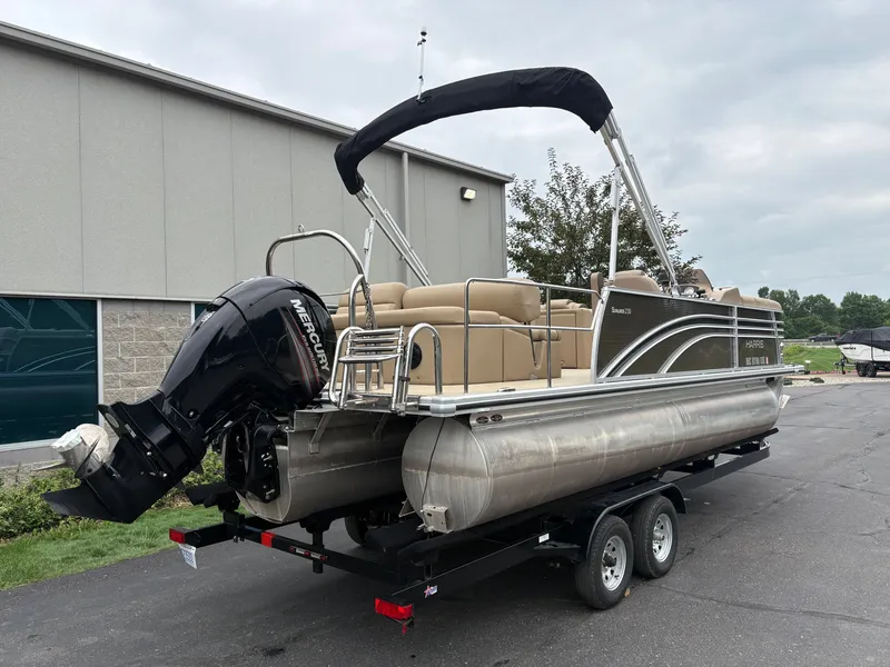 Slide: The Image of A 2019 Harris Sunliner 230 pontoon boat on a trailer in front of a building. - 4