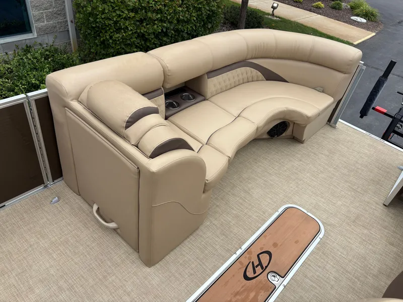 Slide: The Image of The image shows a beige upholstered seating area on a boat, surrounded by green foliage. - 15