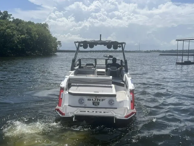 Slide: The Image of A white 2022 Cobalt R8 Surf boat on a lake, surrounded by trees. - 4