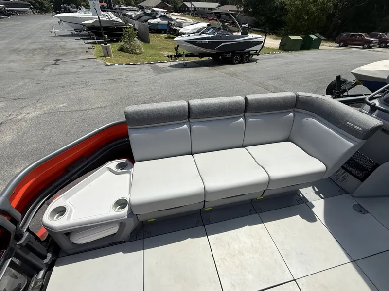 Slide: The Image of The image shows a gray seating area on a 2023 Sea-Doo Switch Cruise, surrounded by other boats. - 10