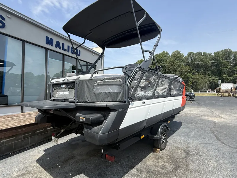 Slide: The Image of A 2023 Sea-Doo Switch Cruise with a black canopy, parked on a trailer in front of a building. - 5