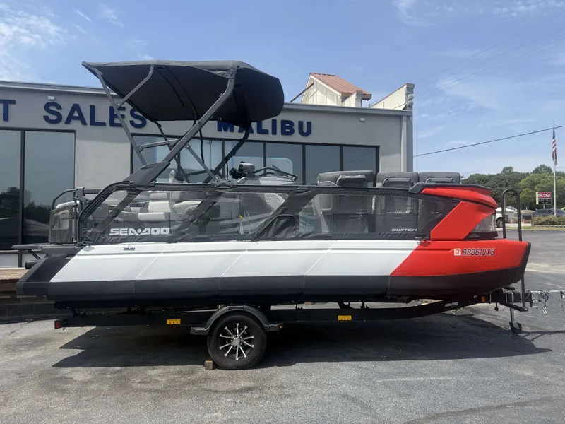 Slide: The Image of A 2023 Sea-Doo Switch Cruise on a trailer in front of a building. It has a modern design. - 6