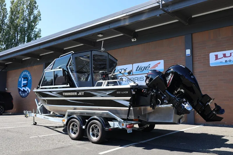 Slide: The Image of 2025 Thunder Jet 200 Luxor boat on trailer at dealership, featuring dual Mercury engines. - 4